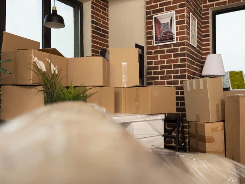 Salon vide avec cartons de déménagement, illustrant le changement de locataire entre une location meublée et une location vide