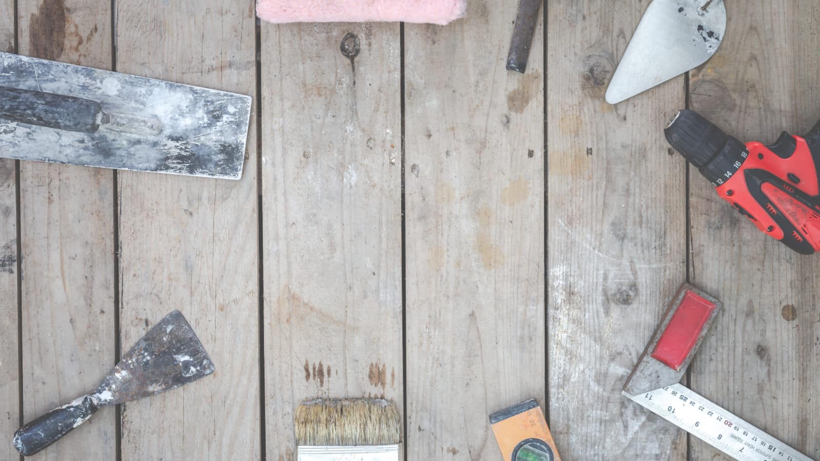 Outils de rénovation posés sur un parquet ancien dans un logement en travaux