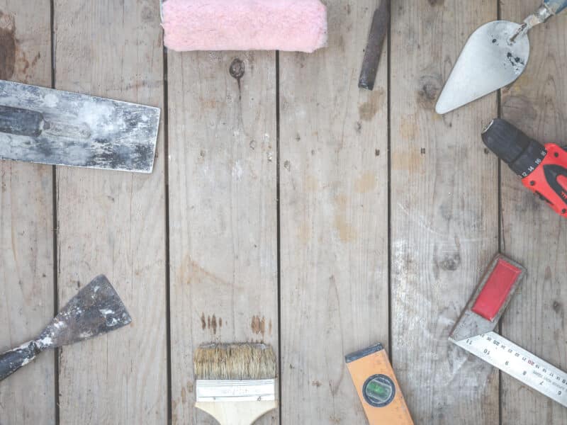 Outils de rénovation posés sur un parquet ancien dans un logement en travaux