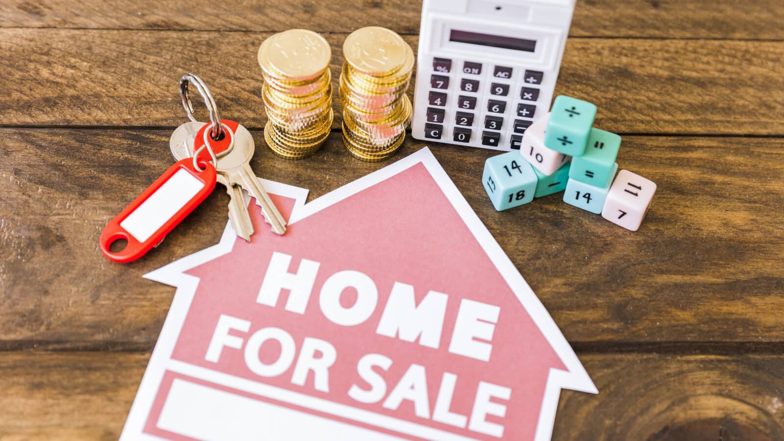 Calculatrice, pièces et clé illustrant le calcul de la plus-value immobilière LMNP