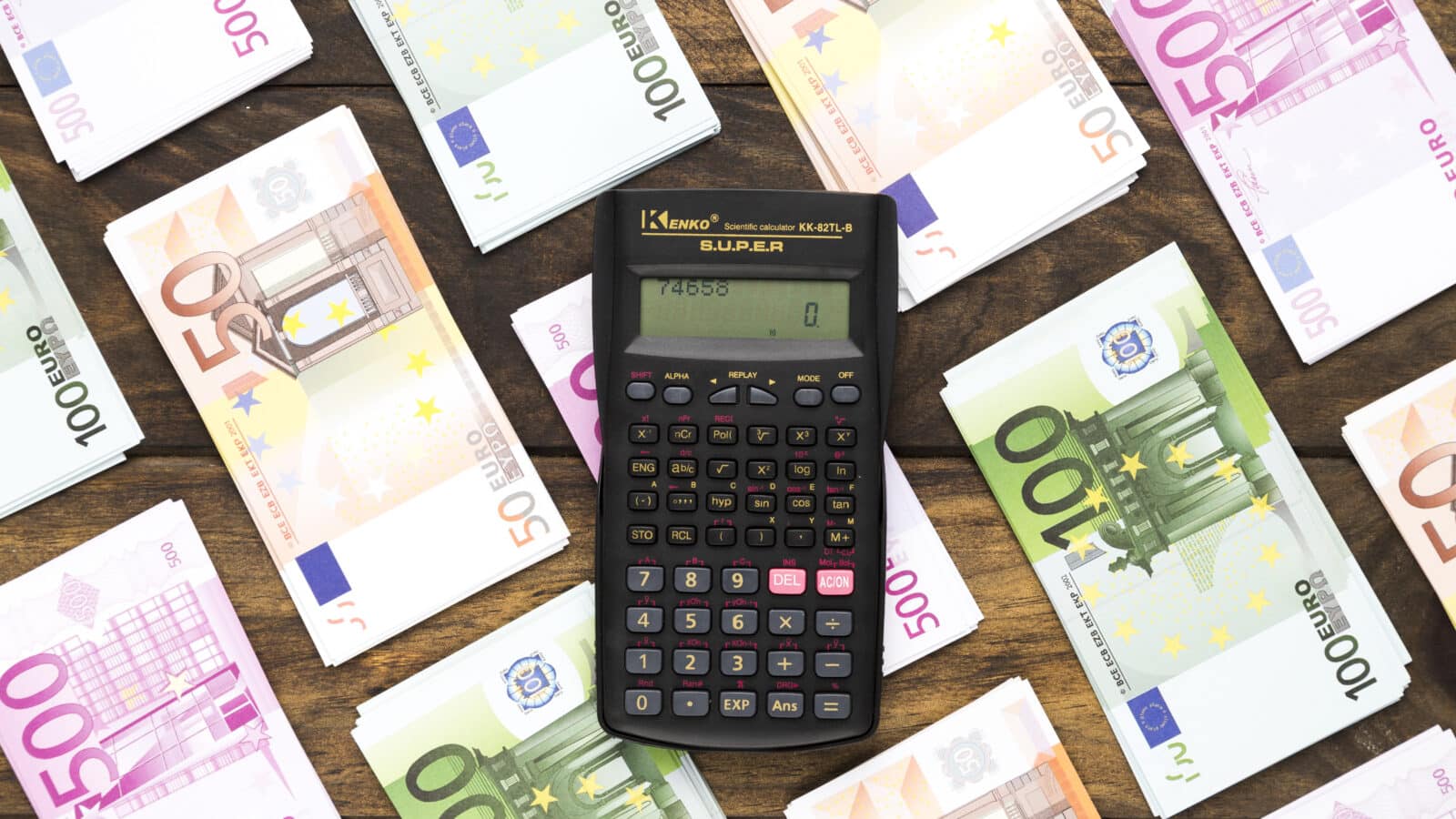 Calculatrice posée sur des billets en euros, illustrant le calcul des prélèvements sociaux et cotisations Urssaf en LMNP
