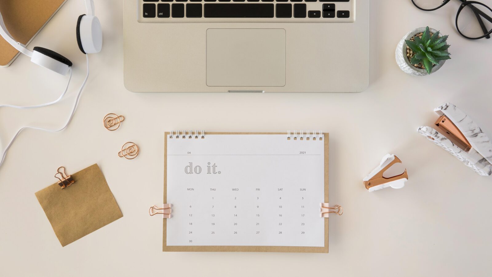 Calendrier de bureau posé sur une table, vu de dessus, symbolisant les échéances fiscales du loueur en meublé