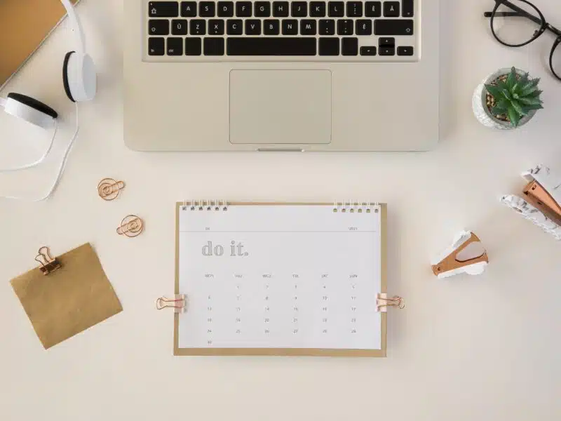 Calendrier de bureau posé sur une table, vu de dessus, symbolisant les échéances fiscales du loueur en meublé
