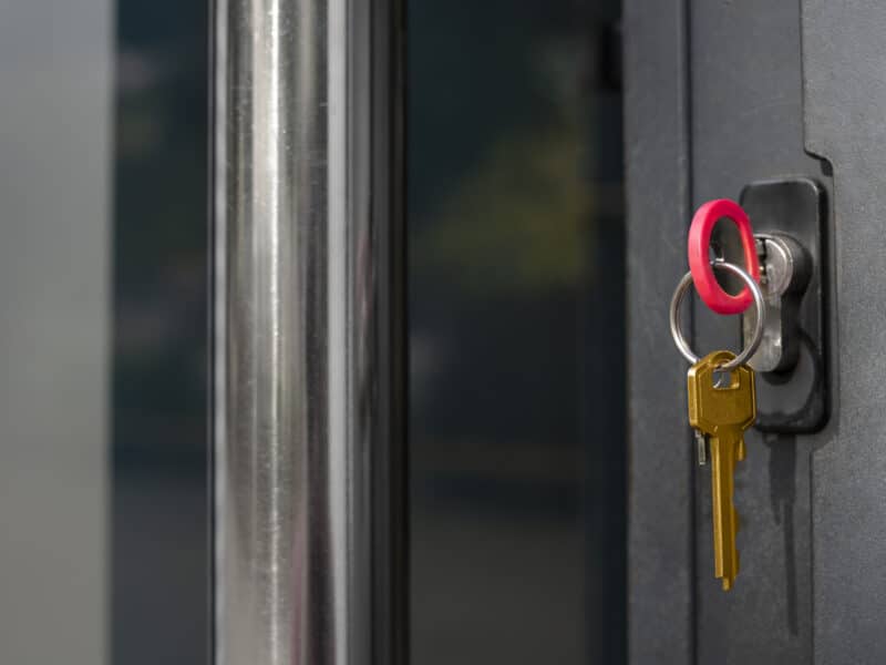 Clé dans la serrure d'une porte d'entrée, symbole du démarrage d'activité de loueur en meublé