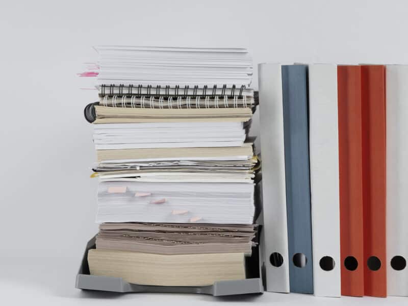 Piles de documents papier empilés sur un bureau, illustrant la liasse fiscale LMNP (formulaire 2031 et annexes 2033)