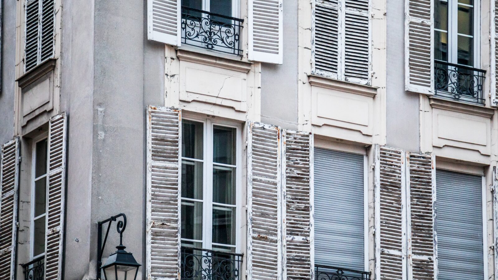 Fenêtres d'un immeuble ancien parisien au soleil, illustration de la CFE due par le loueur en meublé