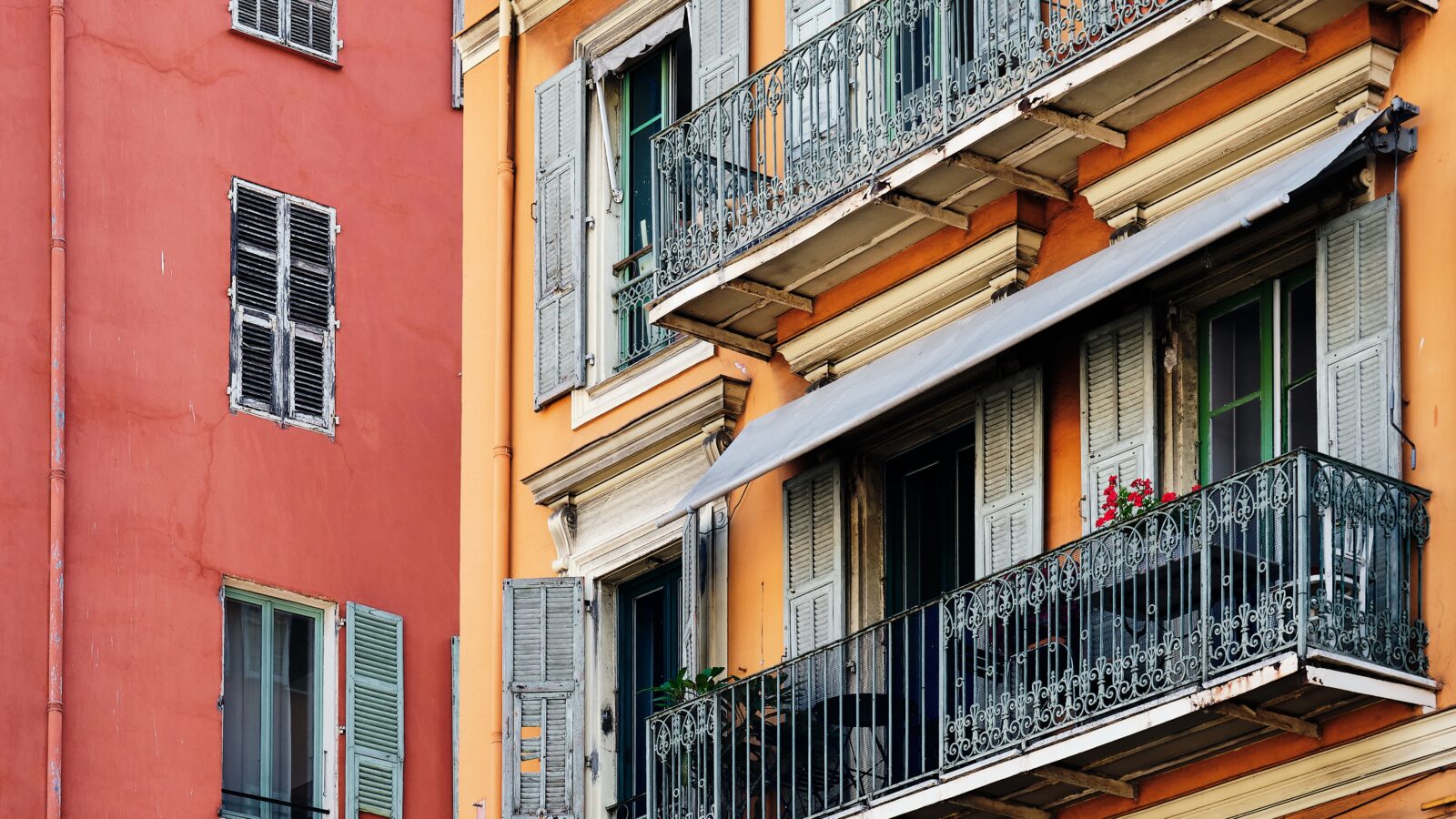 Façade colorée d'un immeuble résidentiel à Nice, illustration du choix entre LMNP et SCI
