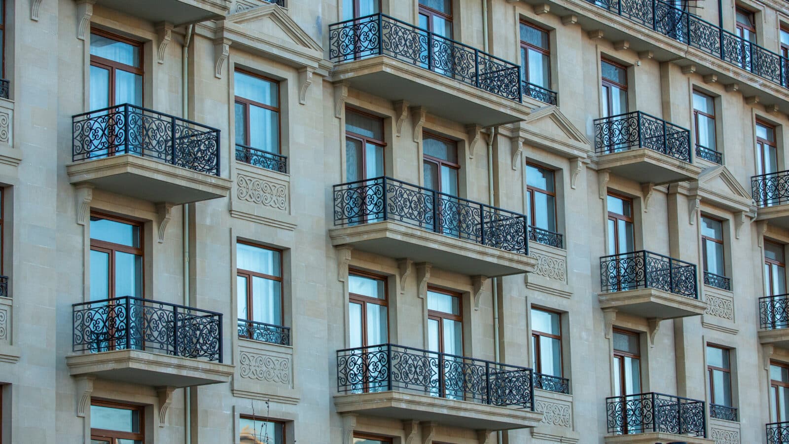Façade d'immeuble parisien avec balcons en fer forgé, photo d'illustration